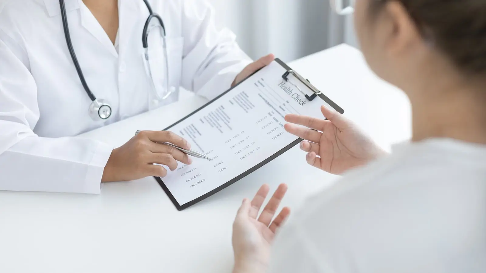 Médica revisando un expediente con su paciente